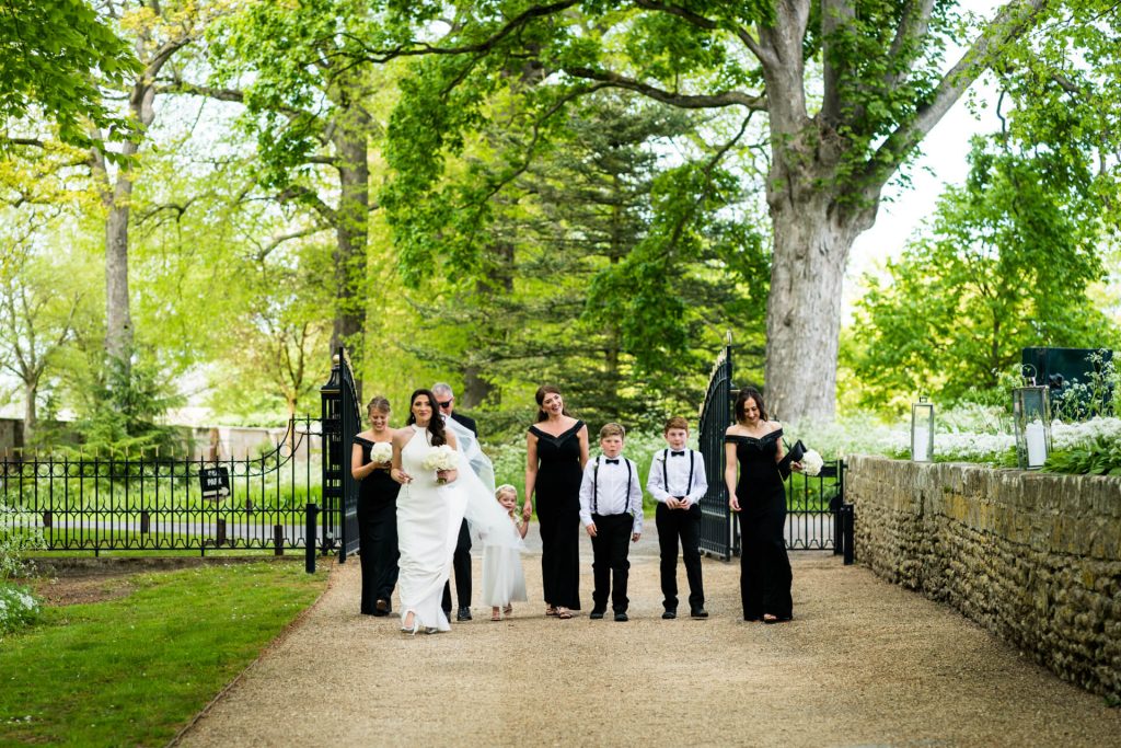 bridal party walk through the gates at the orangery at Settrington