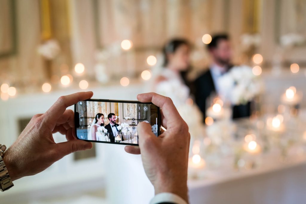 guest taking a picture of the wedding couple