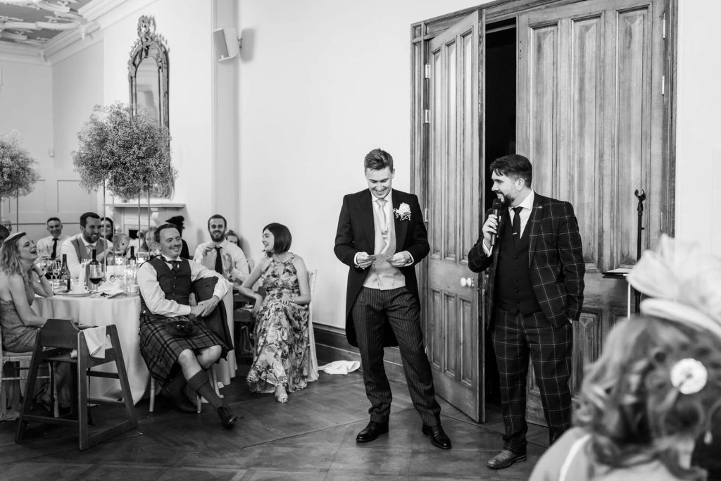 magician talks to the groom who is standing yo in front of the guests
