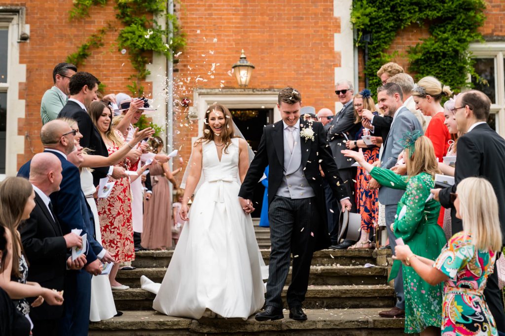 wedding guests shower the couple with confetti at Thicket Priory
