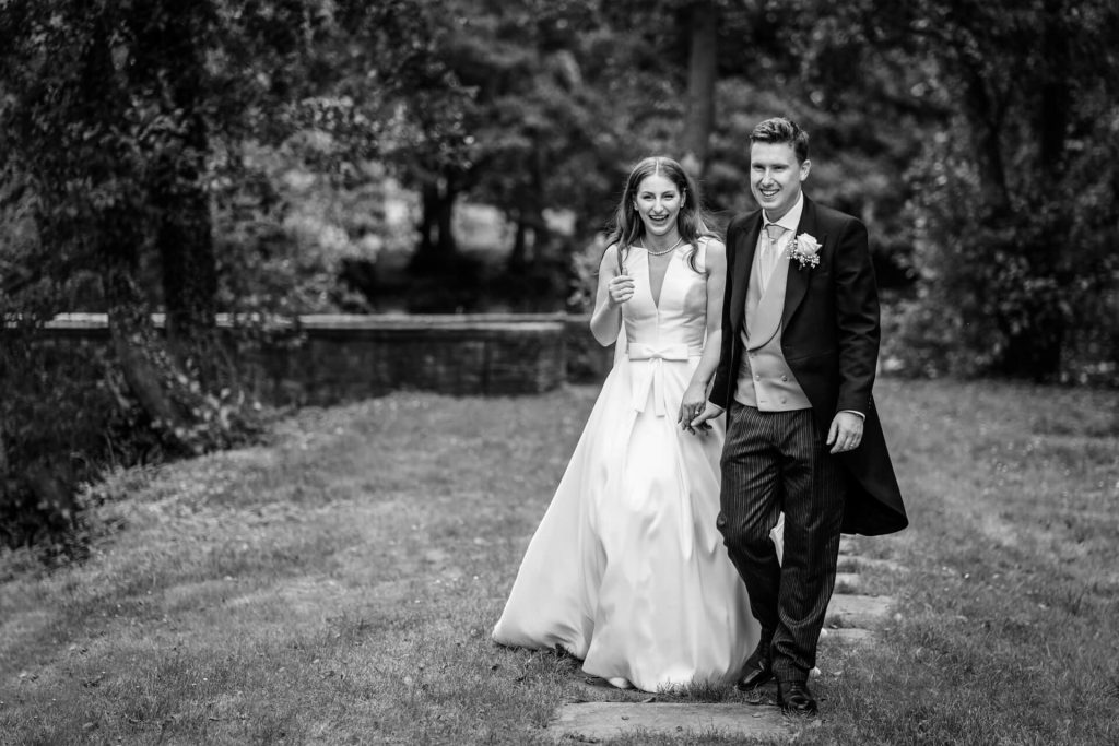 bride and groom walking through the gardens at Thicket Priory