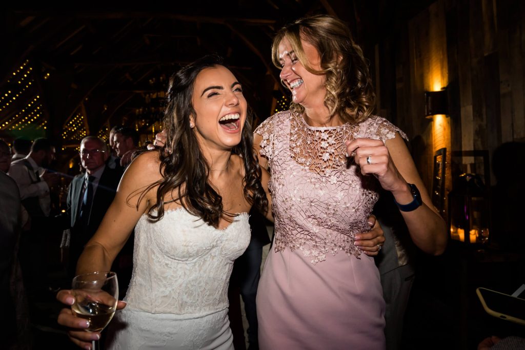 bride and her mum dancing together and laughing