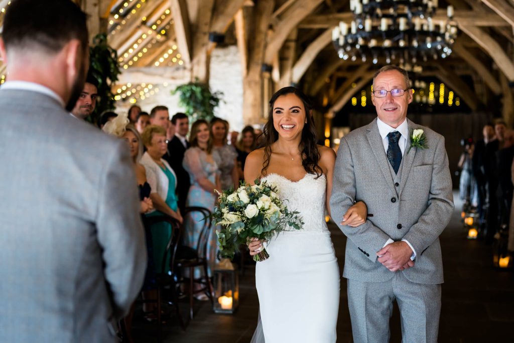 bride and her father walk the aisle at The Tithe Barn