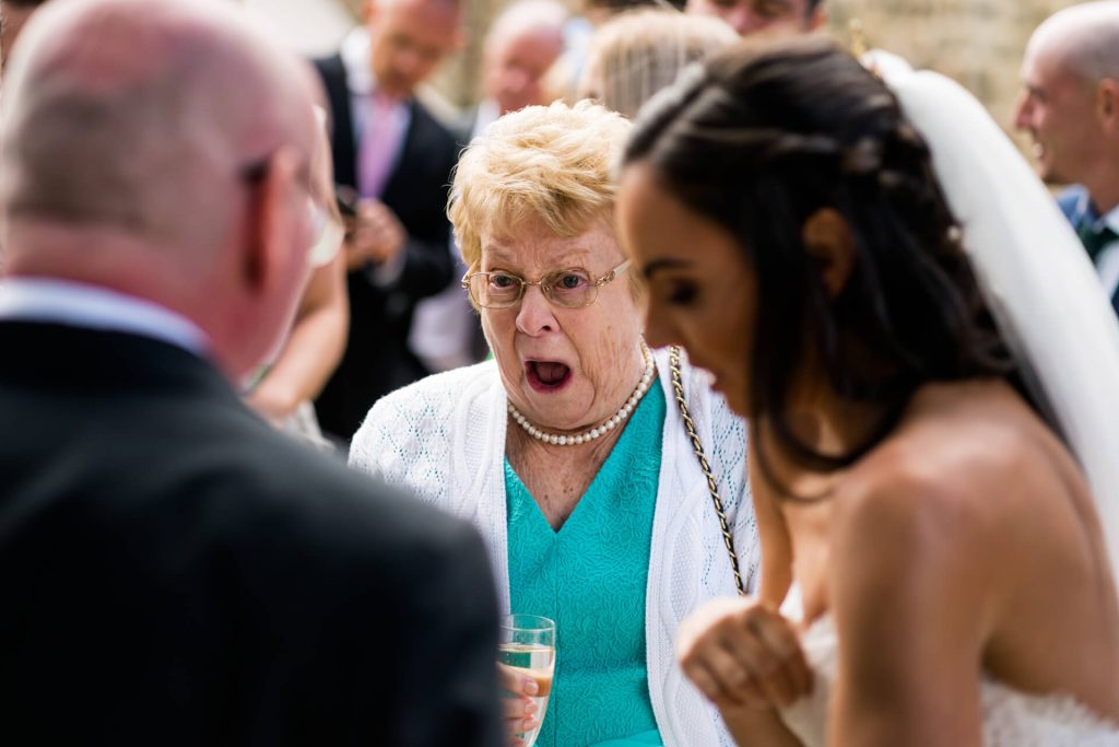 a wedding guest laughs whilst talking to the bride