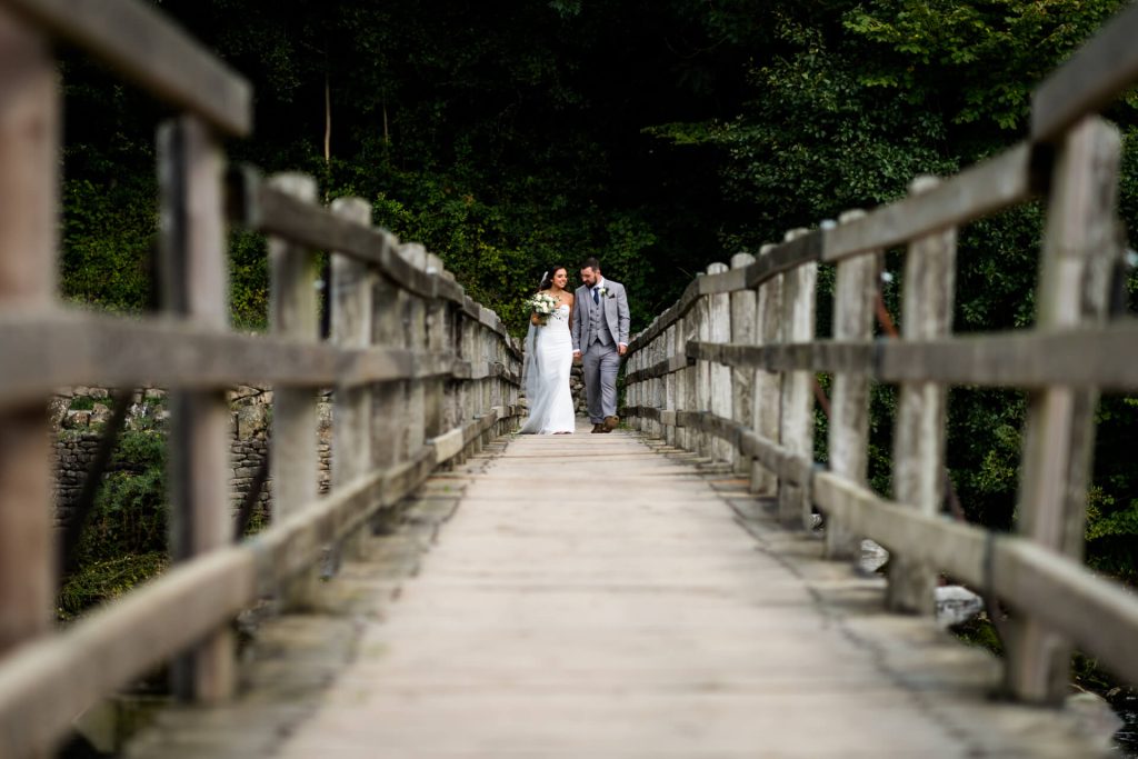 wedding couple walking along a bride at Bolton Abbey