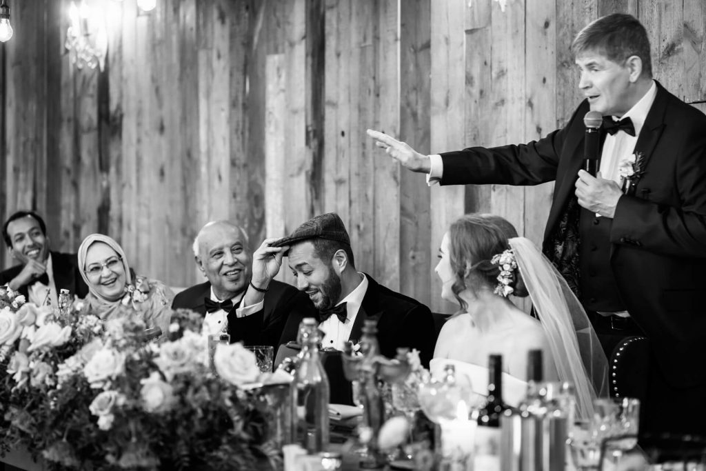 family laughing whilst the father of the bride gives his speech