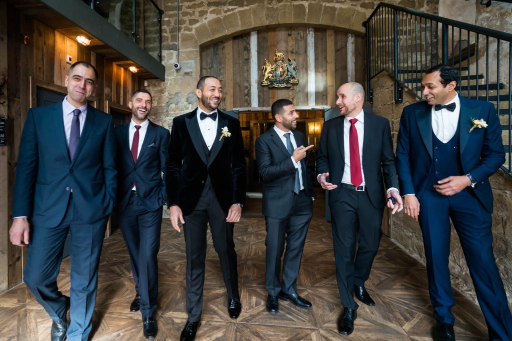 groom and his groomsmen walking through the wedding venue