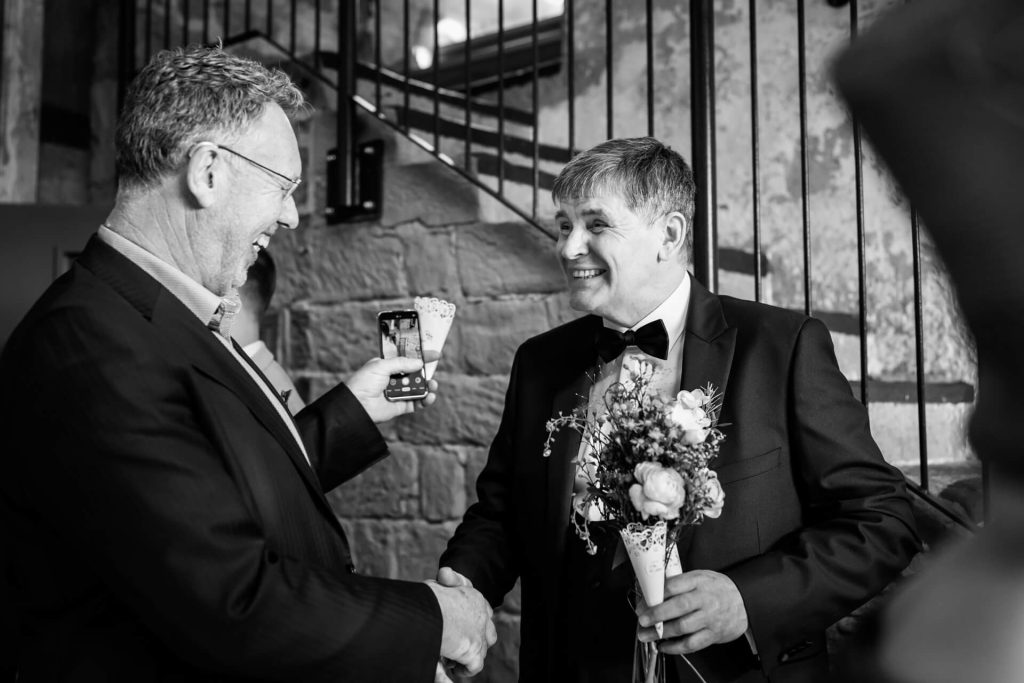 father of the bride shakes hand with a wedding guest
