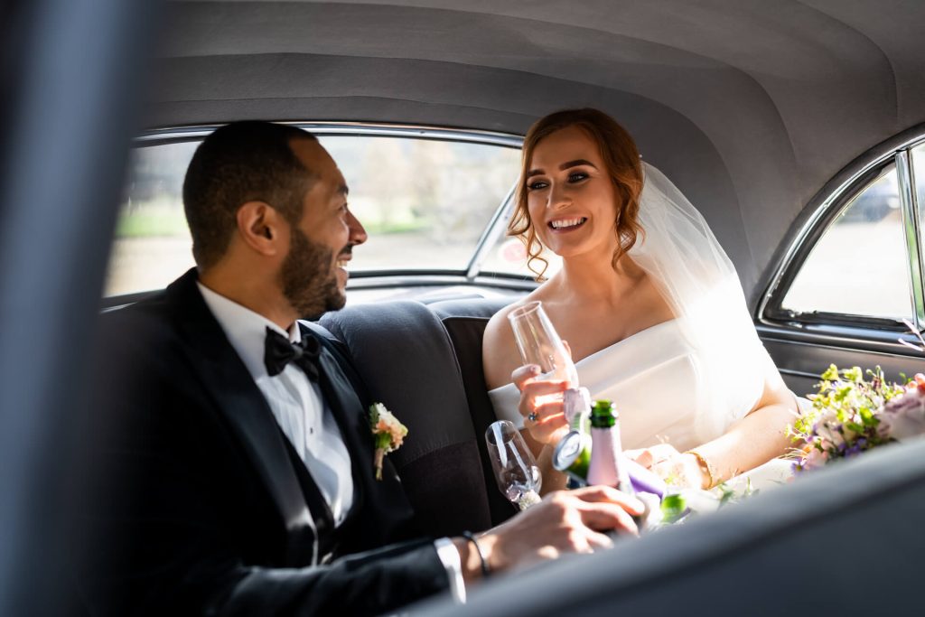 bride and groom toasting in the wedding car outside Wharfedale Grange