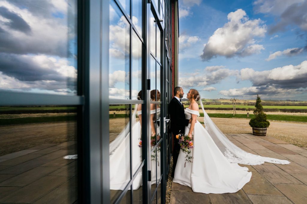 bride and groom in front of the big glass doors at Wharfedale Grange