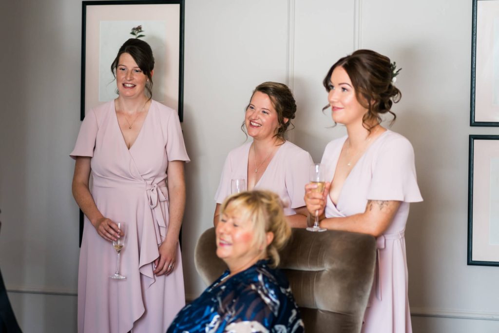 bridesmaids smiling and holding champagne flutes