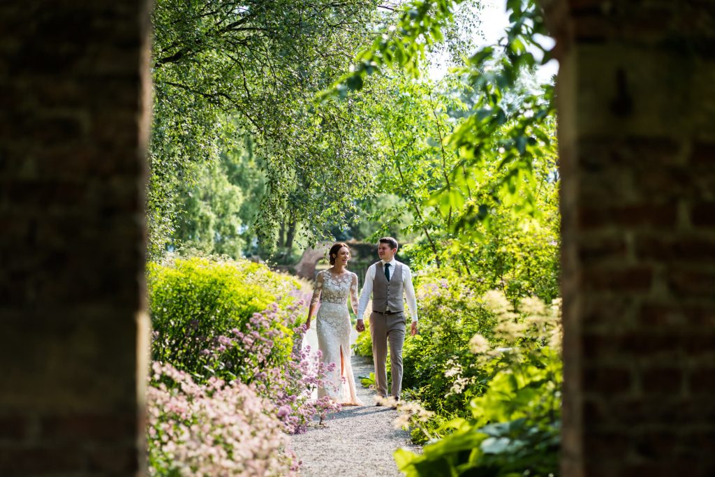 wedding couple walking through the gardens on the Middleton Lodge estate