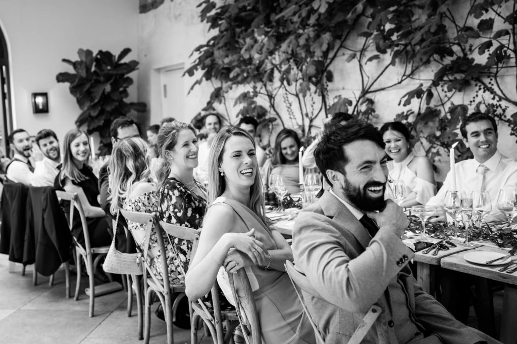 wedding guests laughing during the speeches
