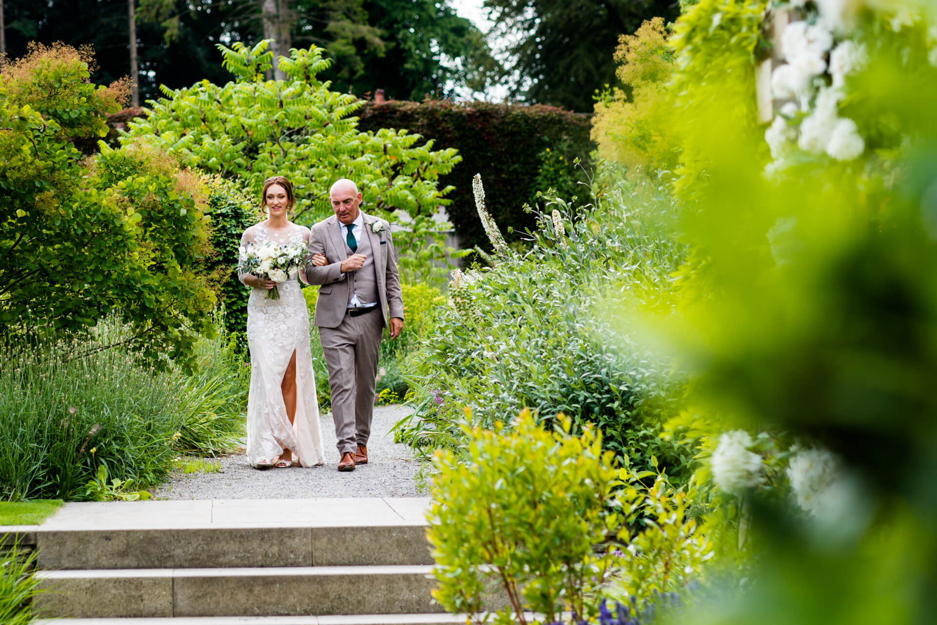 bride and her father walking down the path to the wedding ceremony at Middleton Lodge
