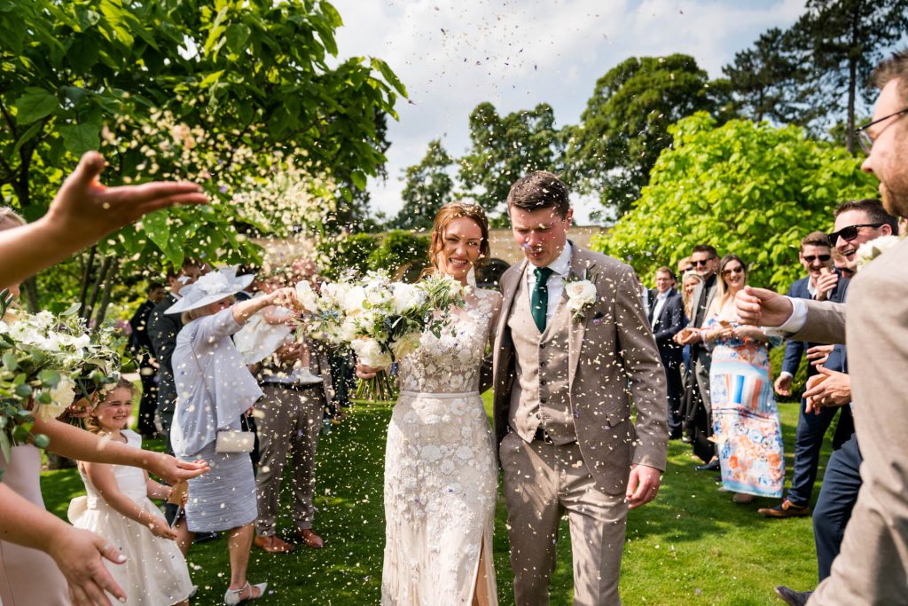 wedding couple being bombarded with confetti on the Middleton Lodge estate