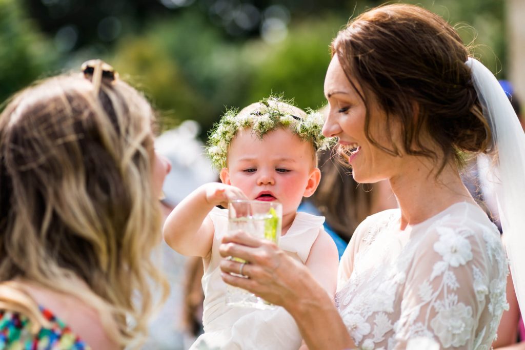 brides baby girl putting her hand in a glass of water