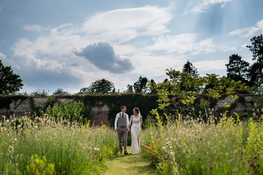 bride and groom walking hand in hand in the gardens at Middleton Lodge