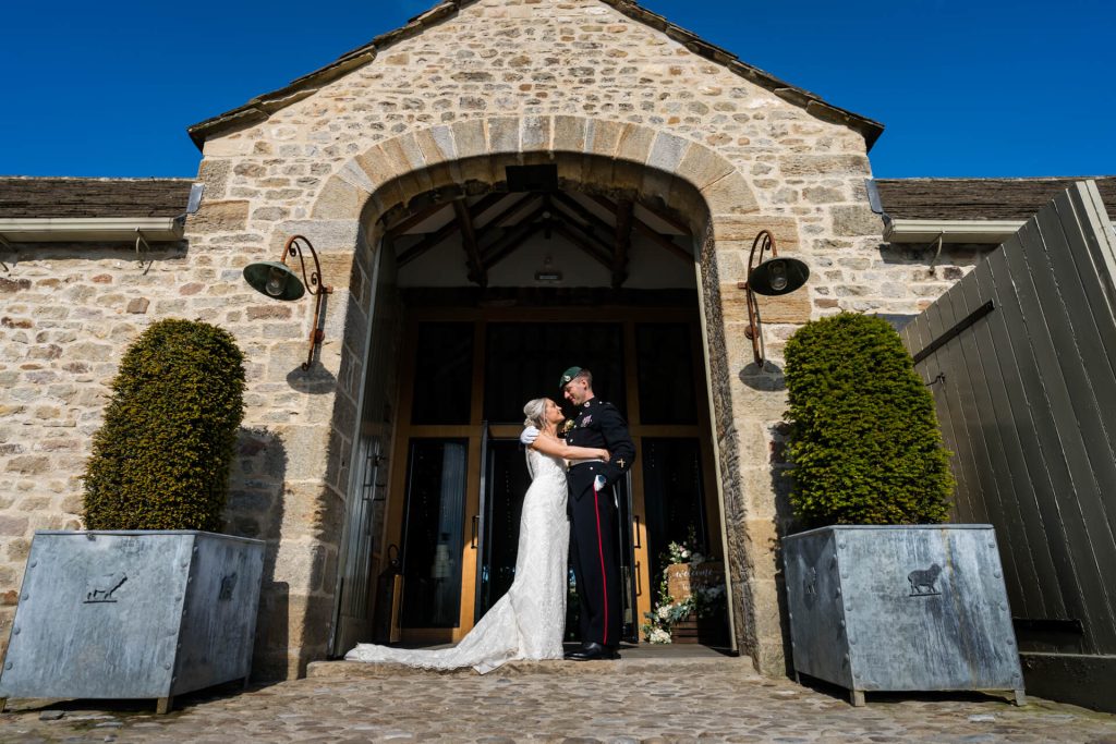 wedding couple hugging in the archway at ithe Barn