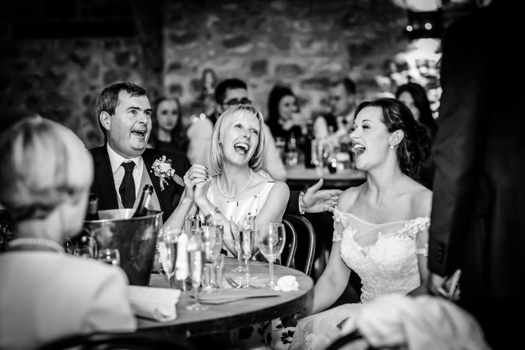 family laughing during the wedding speeches