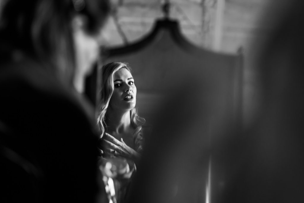bride looking in a mirror and fixing her hair