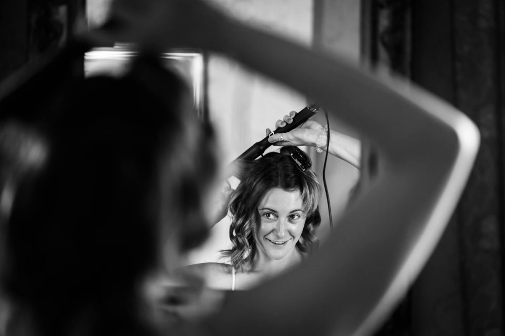 bridesmaid fixing her hair in a mirror