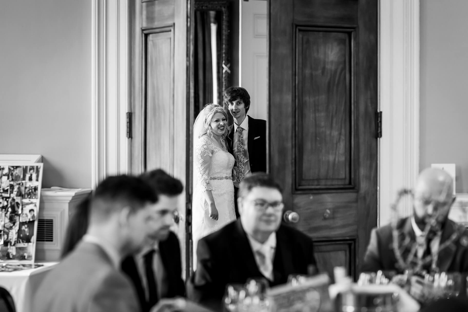 bride and groom seen through the doorway to the reception room at Rudding Park