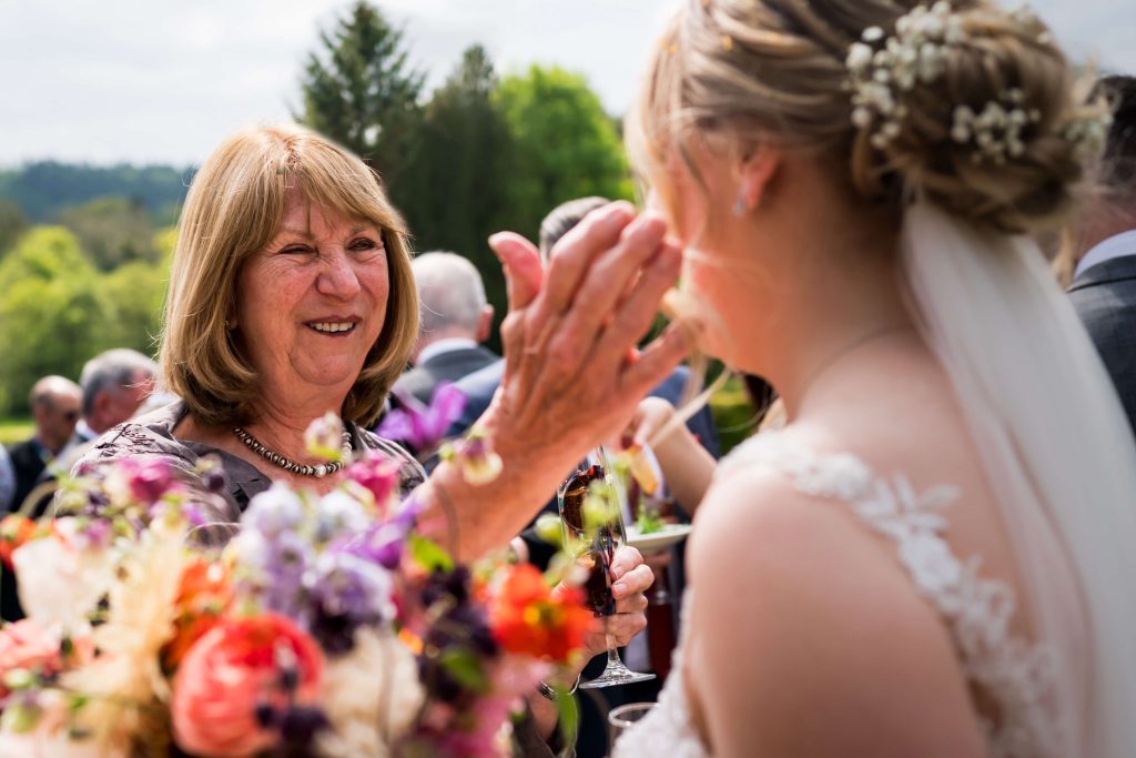 Guest smiling at bride affectionately at wedding reception