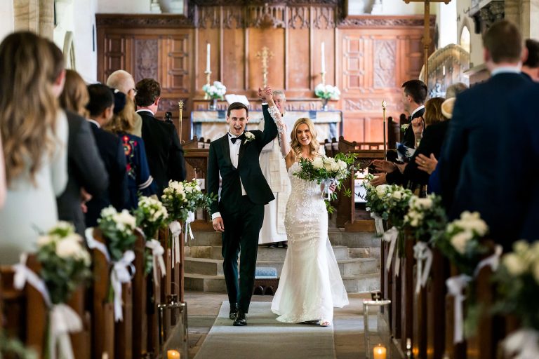 Bride and groom walking down church aisle at the Orangery at Settrington