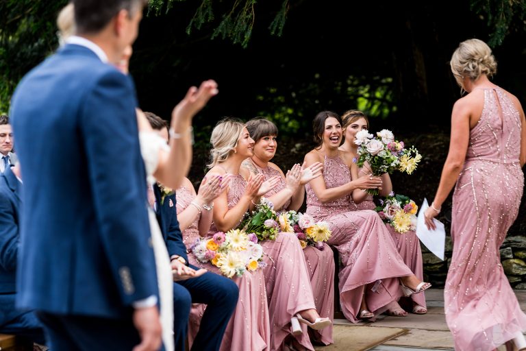 Bridesmaids clapping at a garden wedding ceremony as a bridesmaid finishes her speech, at Towhead Estate