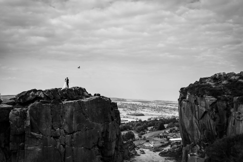 Wedding couple on cliff, scenic landscape, black and white photo