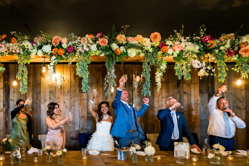 Joyful wedding toast celebration with floral decor at Wharfedale Grange