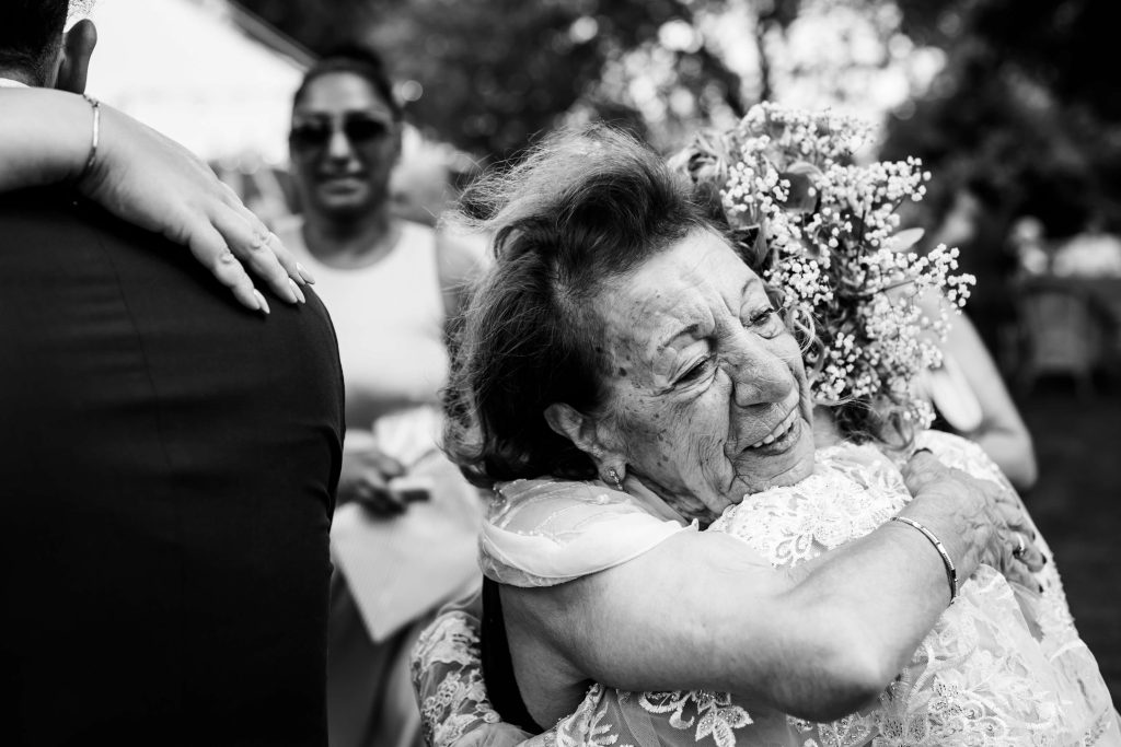Elderly woman joyfully hugging the bride