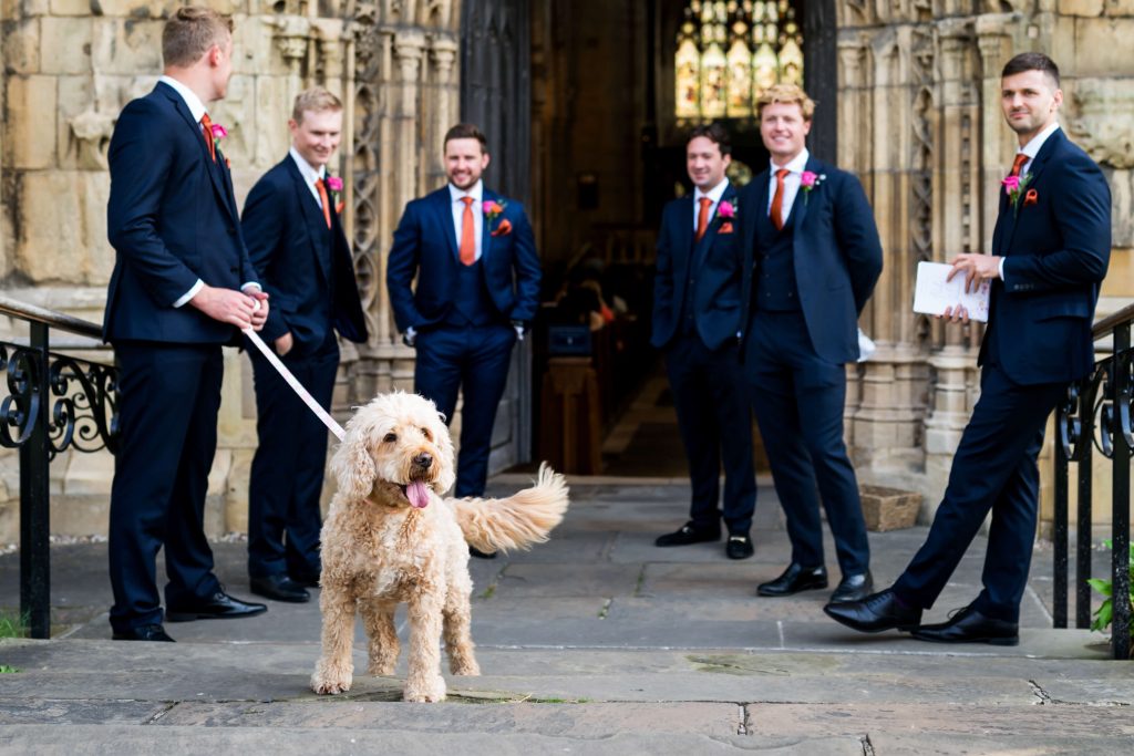Dog with groomsmen outside the church