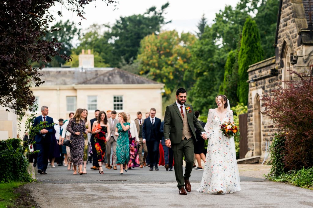 Bride and groom walking with guests at a Rudding park wedding