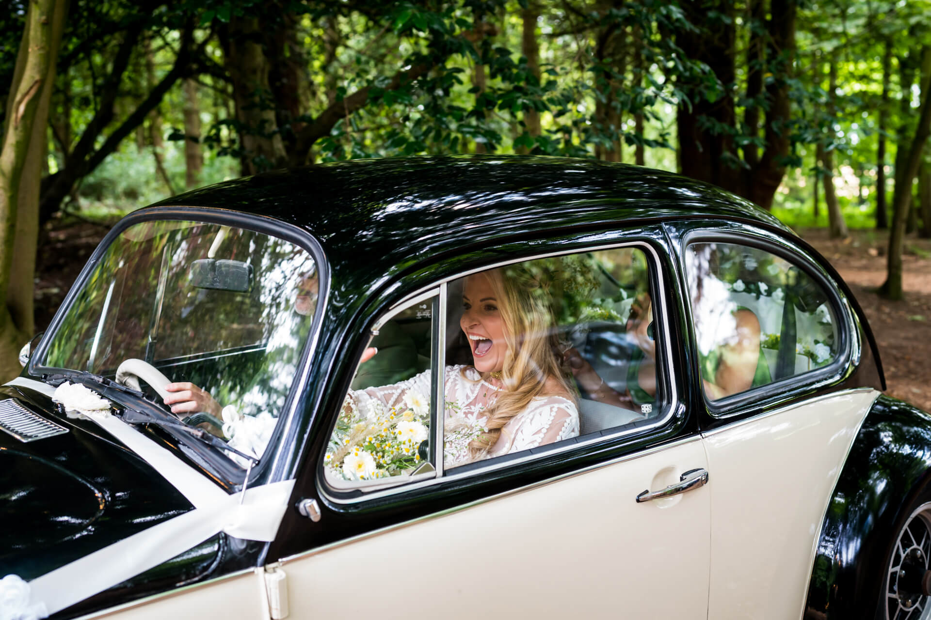 Joyful bride in vintage car on wedding day.
