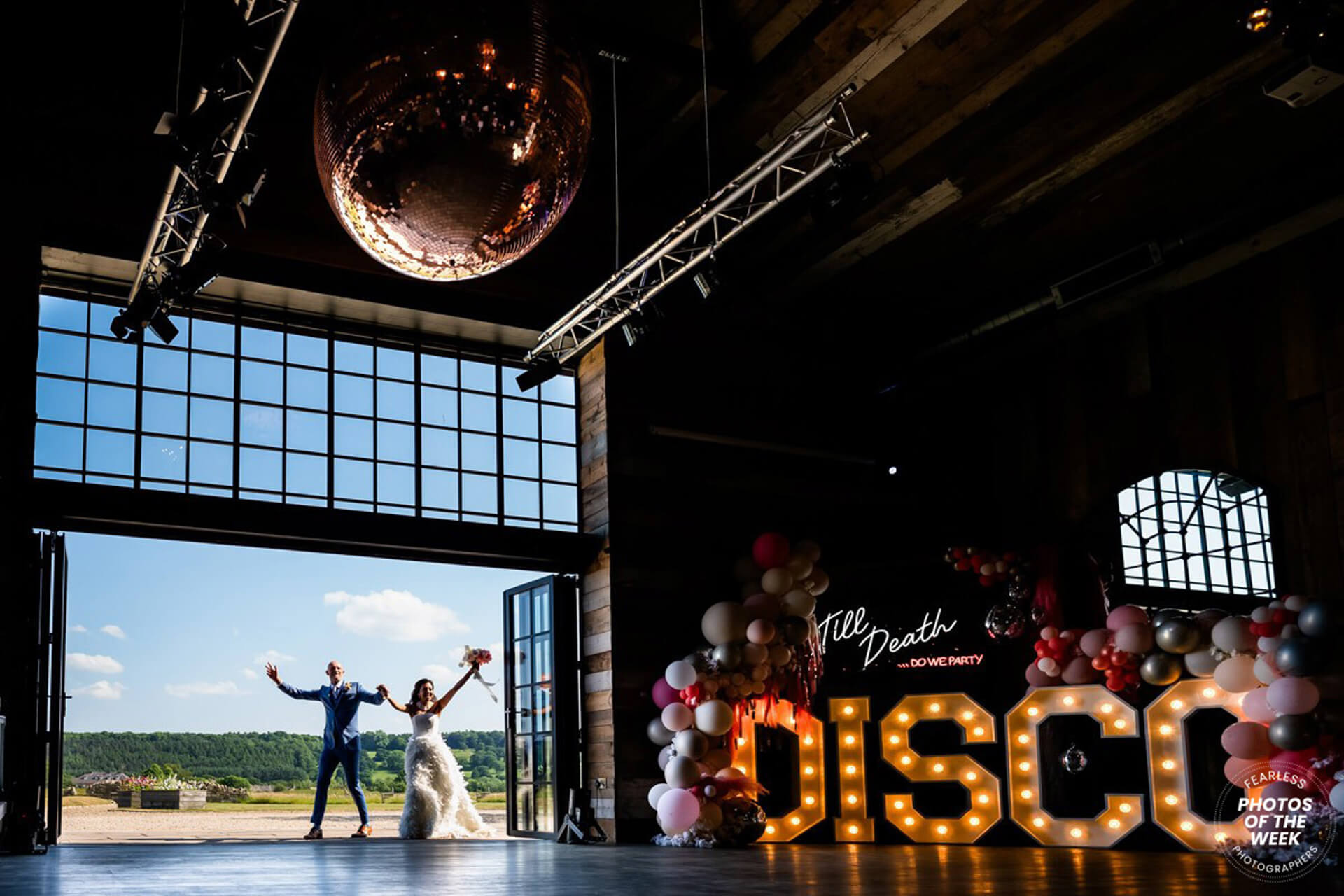 Wedding couple entering Wharfedale Grange Barn with disco lights