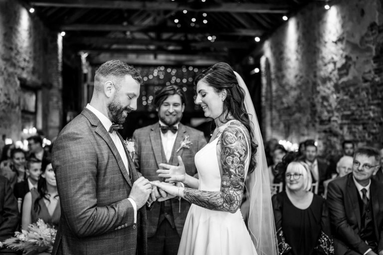 Bride and groom exchanging rings at The Normans wedding barn