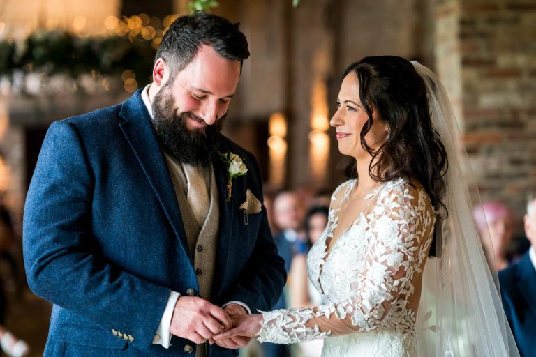 Bride and groom smiling during wedding ring exchange