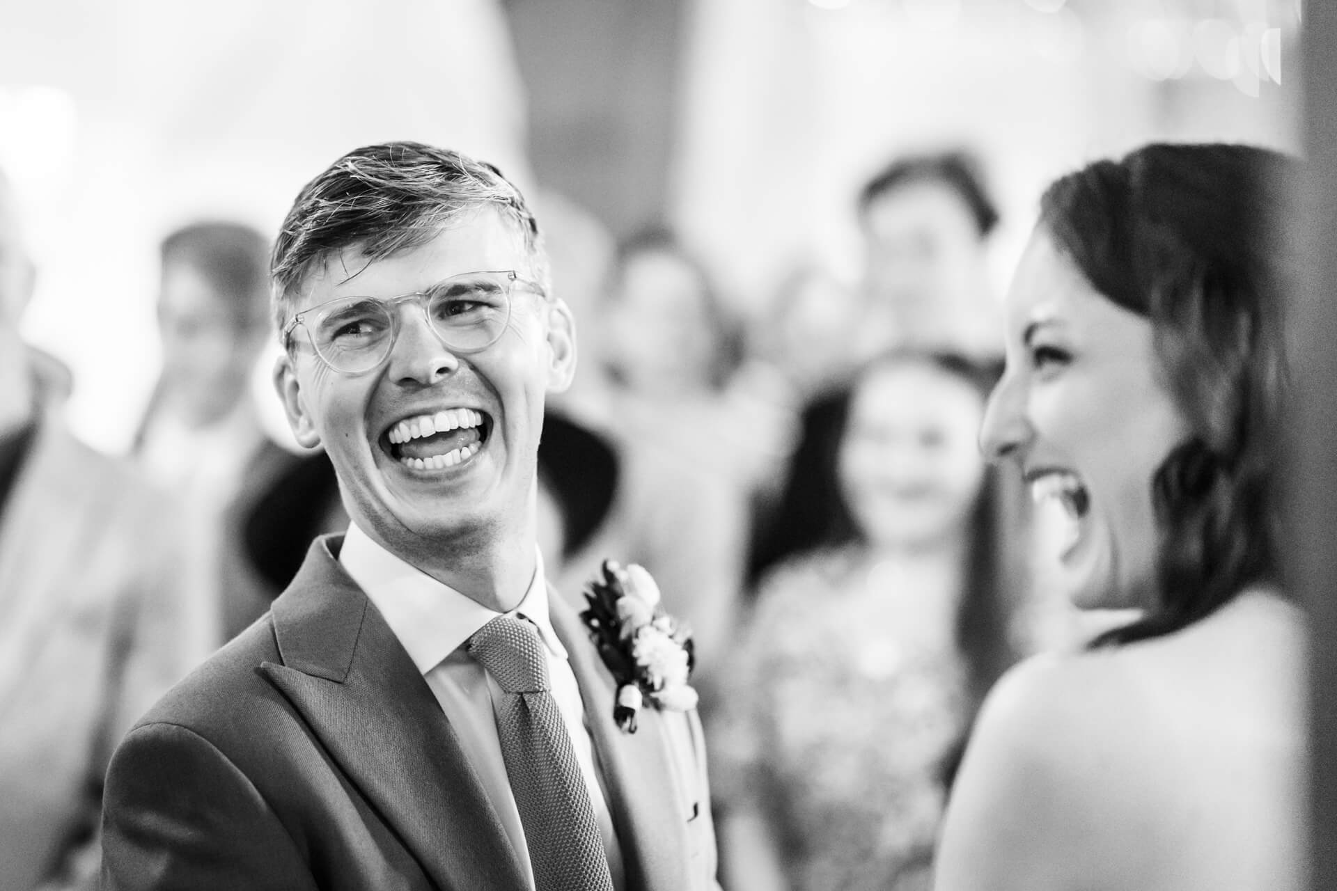 Joyful wedding couple laughing in black and white photo