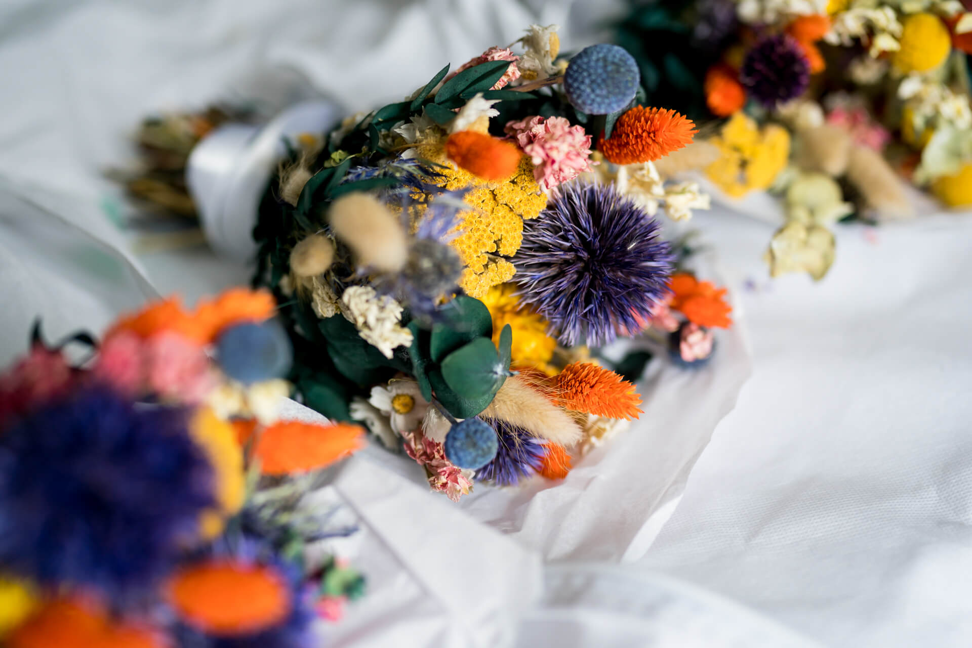 Vibrant dried flower bouquet on white fabric