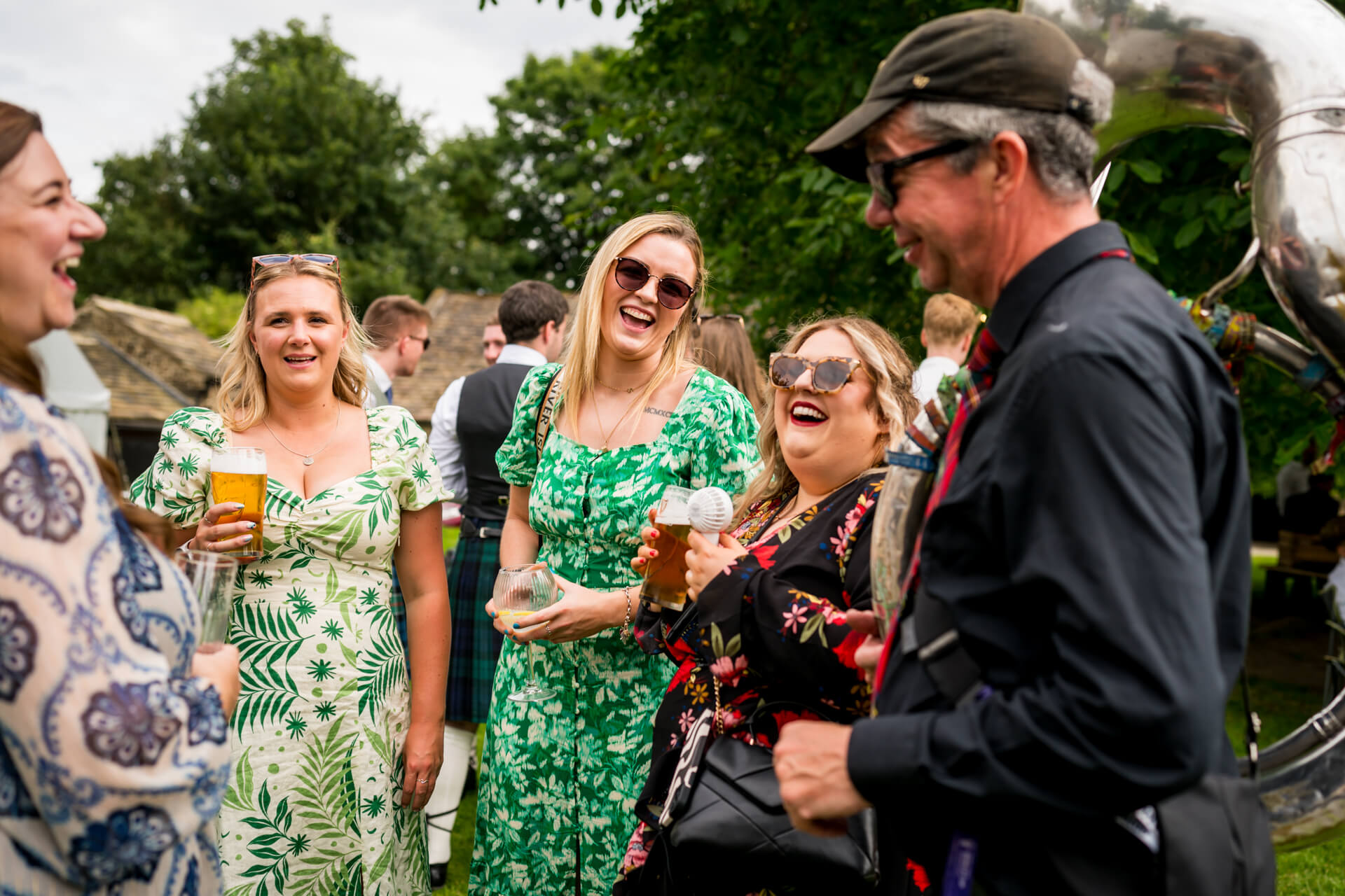 Outdoor gathering with joyful people holding drinks