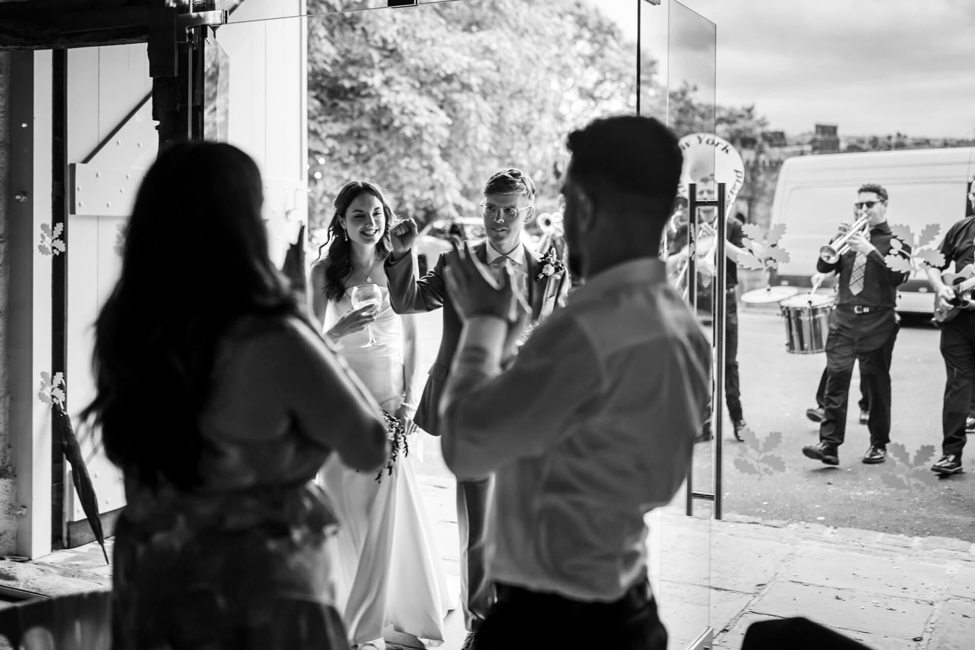 Bride and groom greeting guests with musicians in background