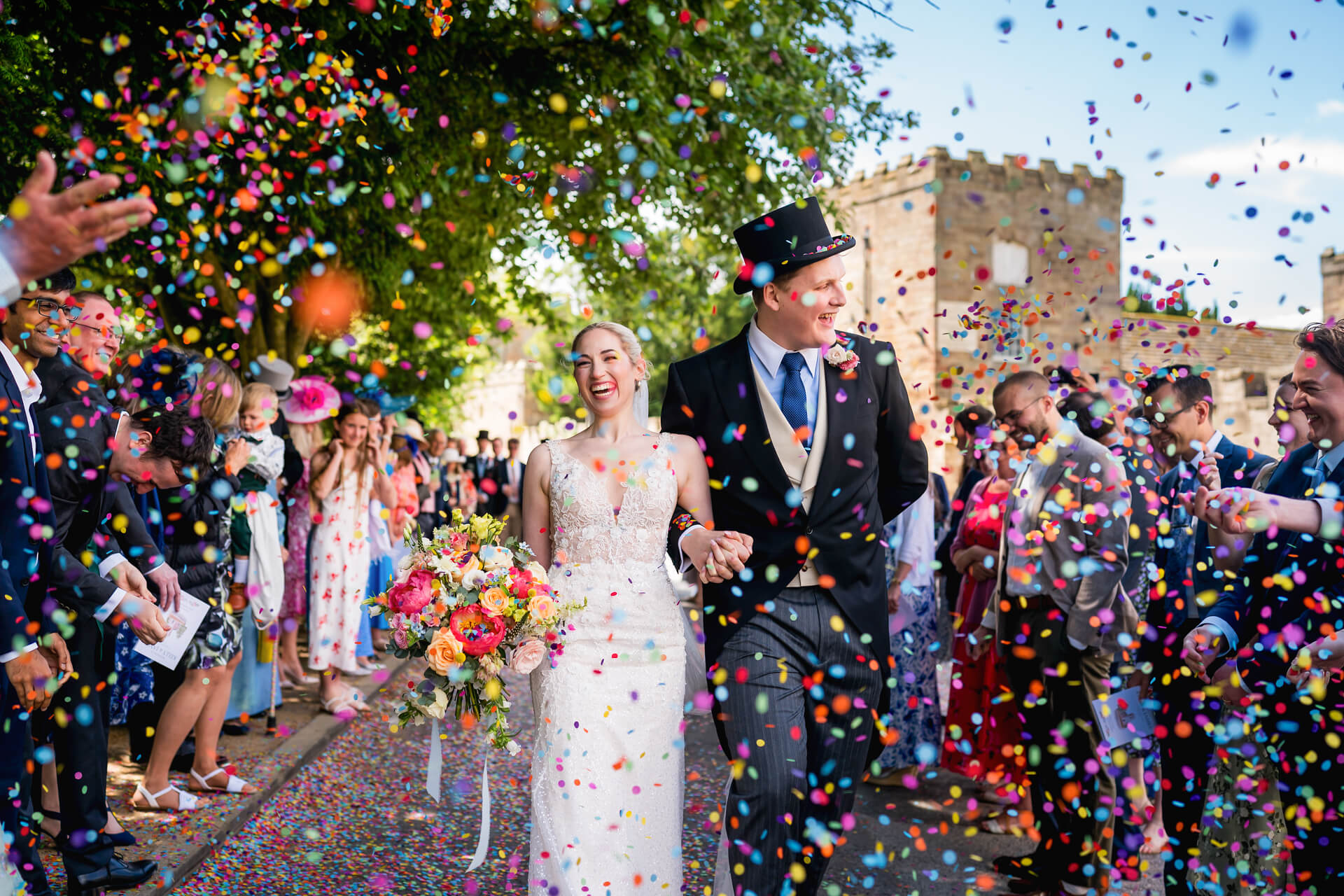 Bride and groom walking through confetti at wedding.