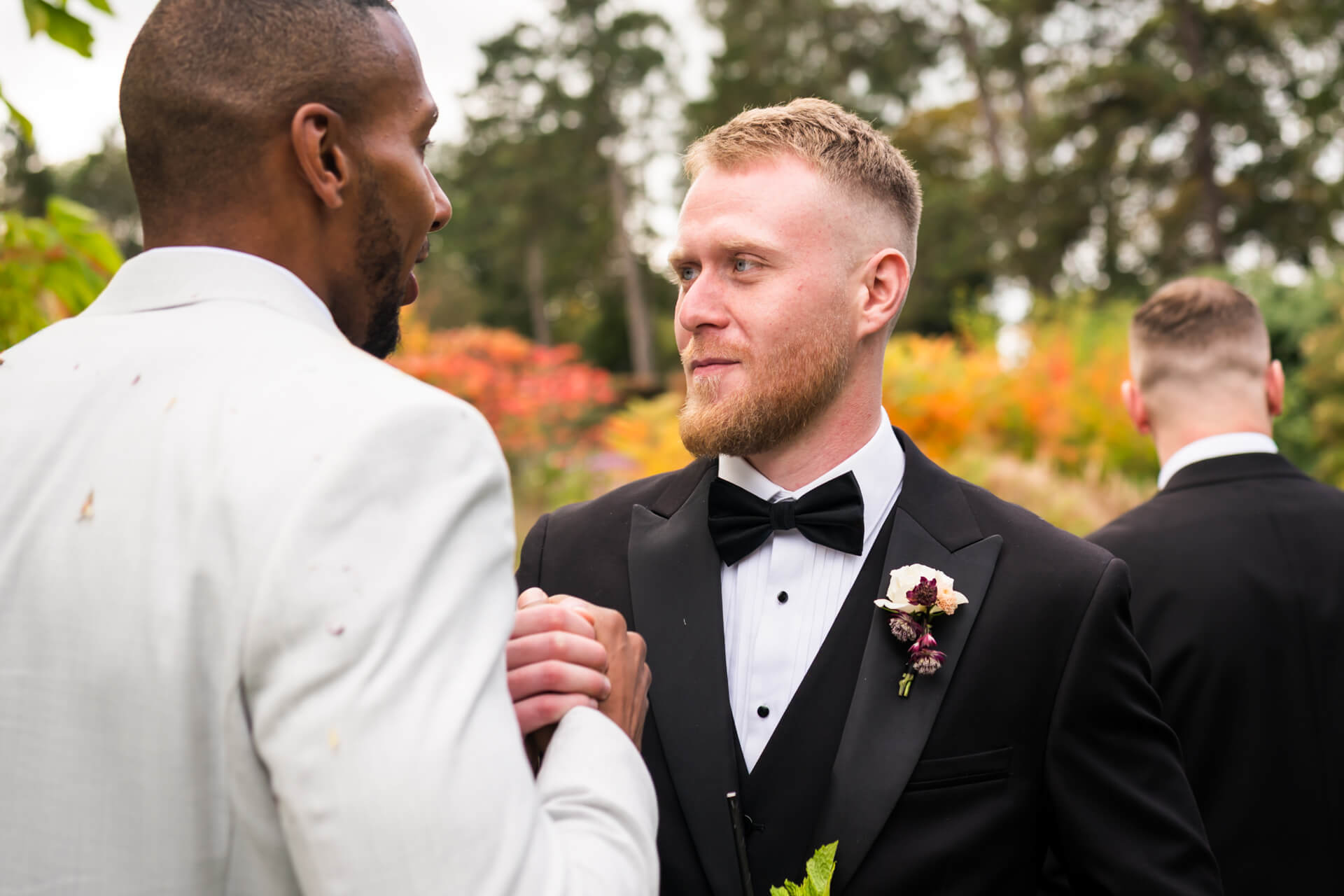 Groomsmen shaking hands at outdoor wedding