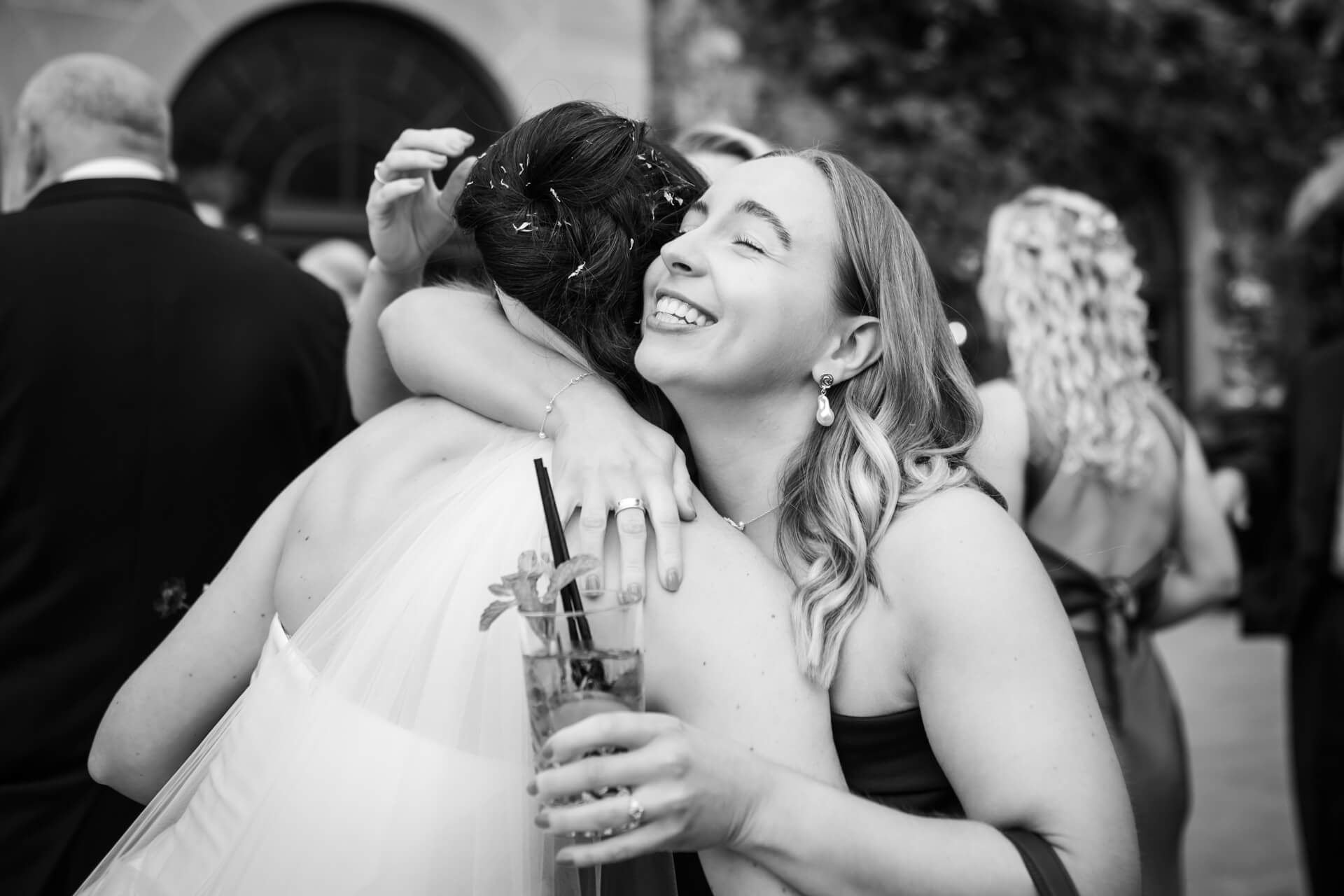 Two women hugging joyfully at an event.