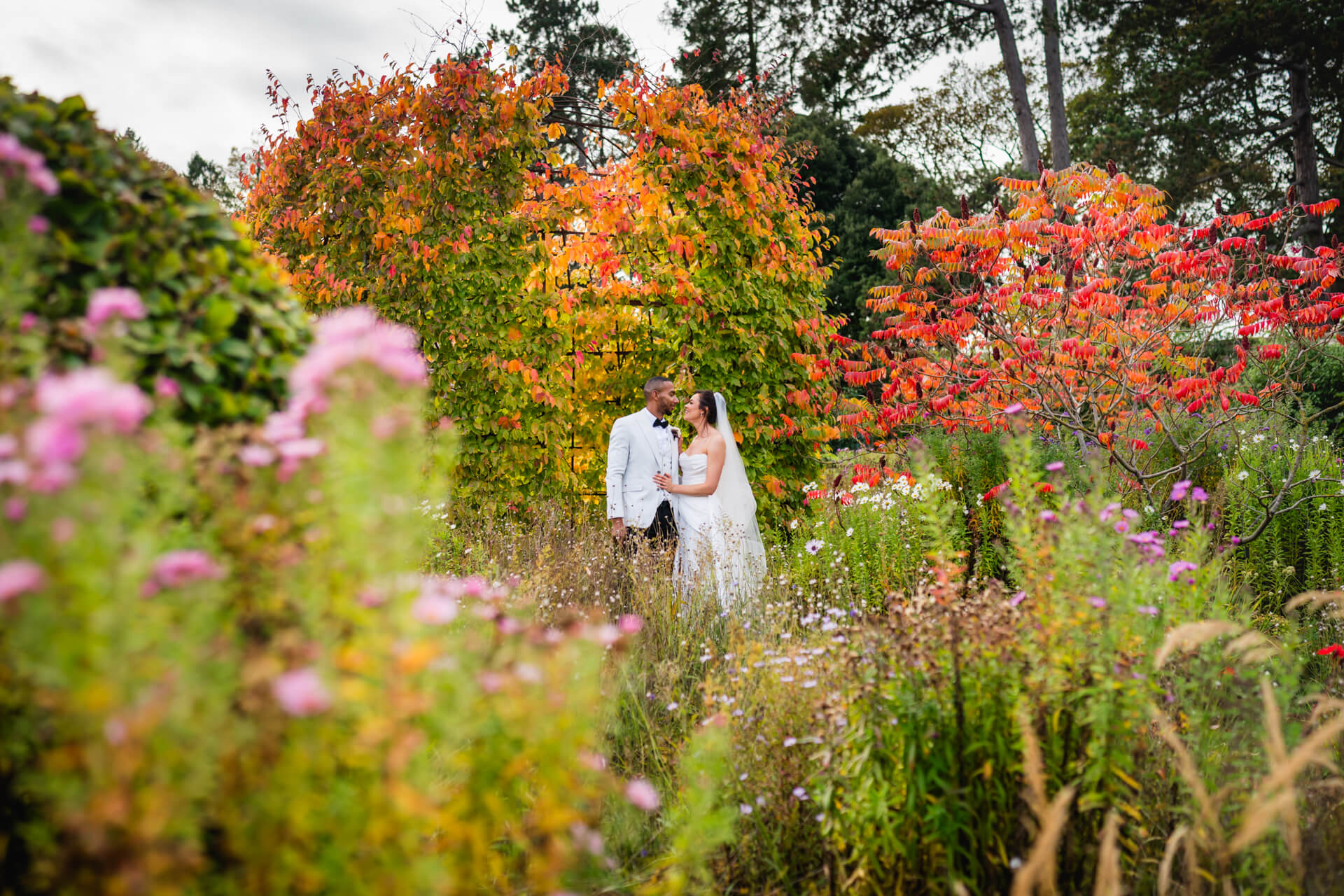 Couple embracing in colourful autumn garden.