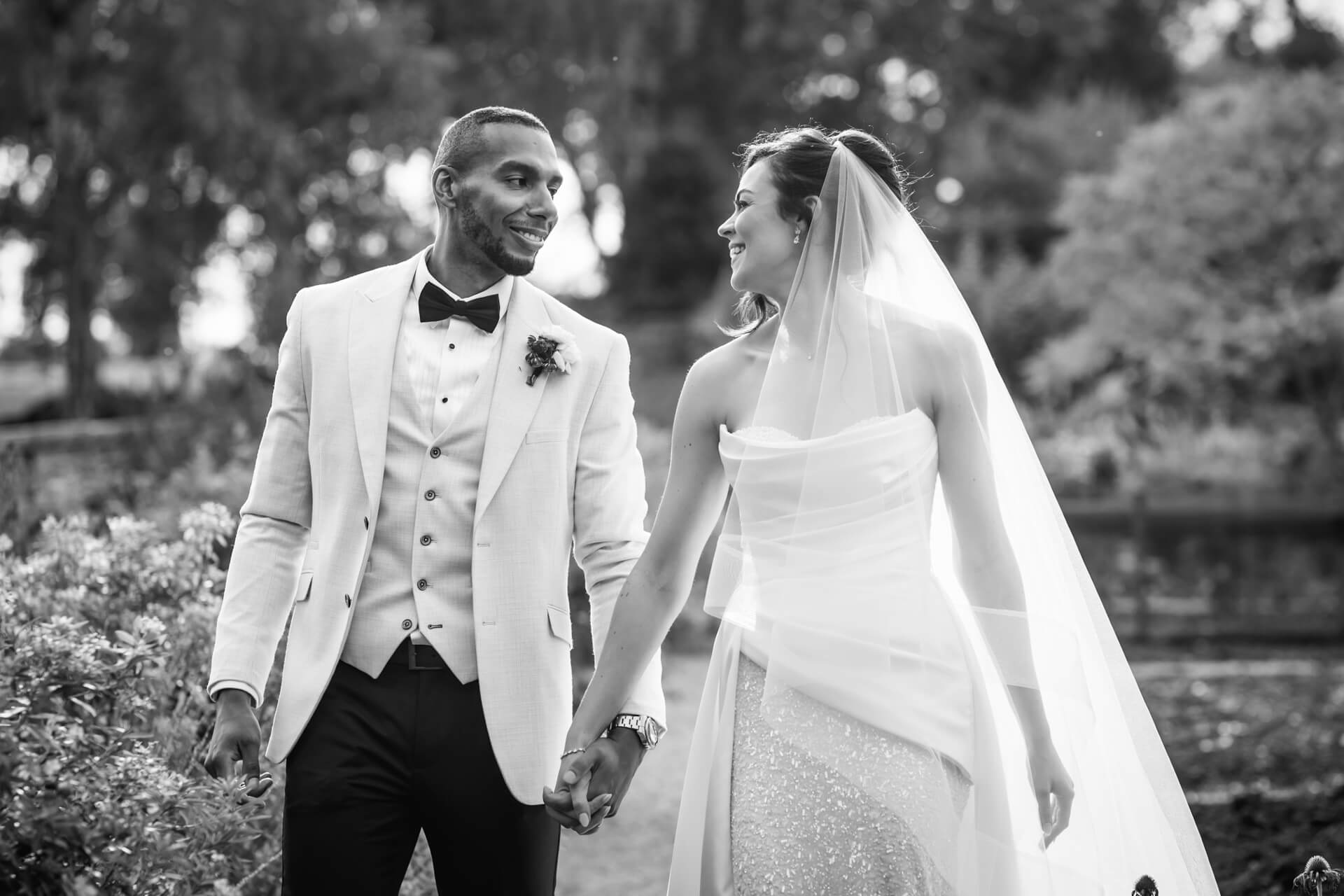 Happy couple walking hand-in-hand on wedding day.