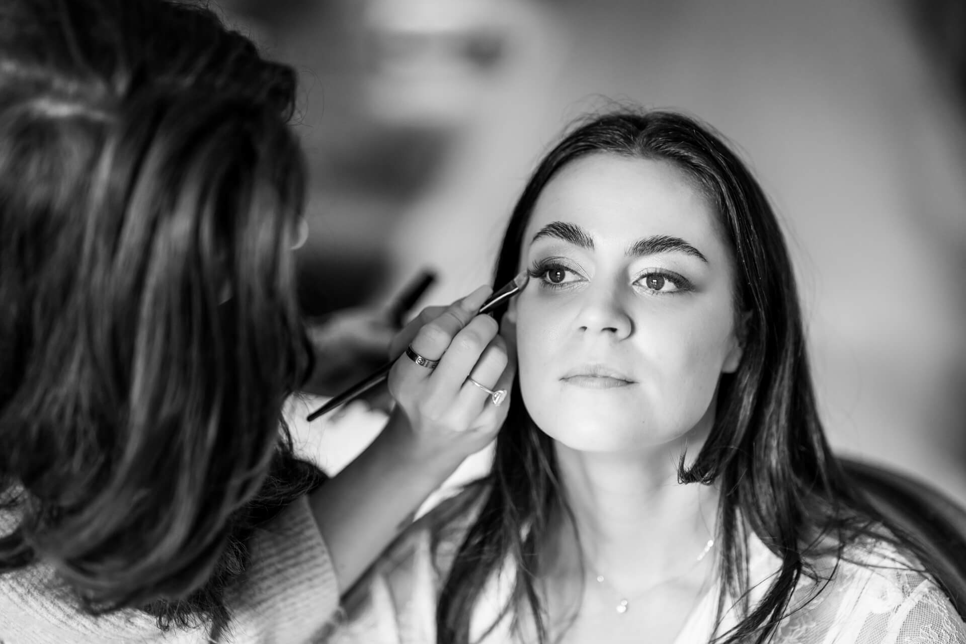Makeup artist applying eyeshadow to woman