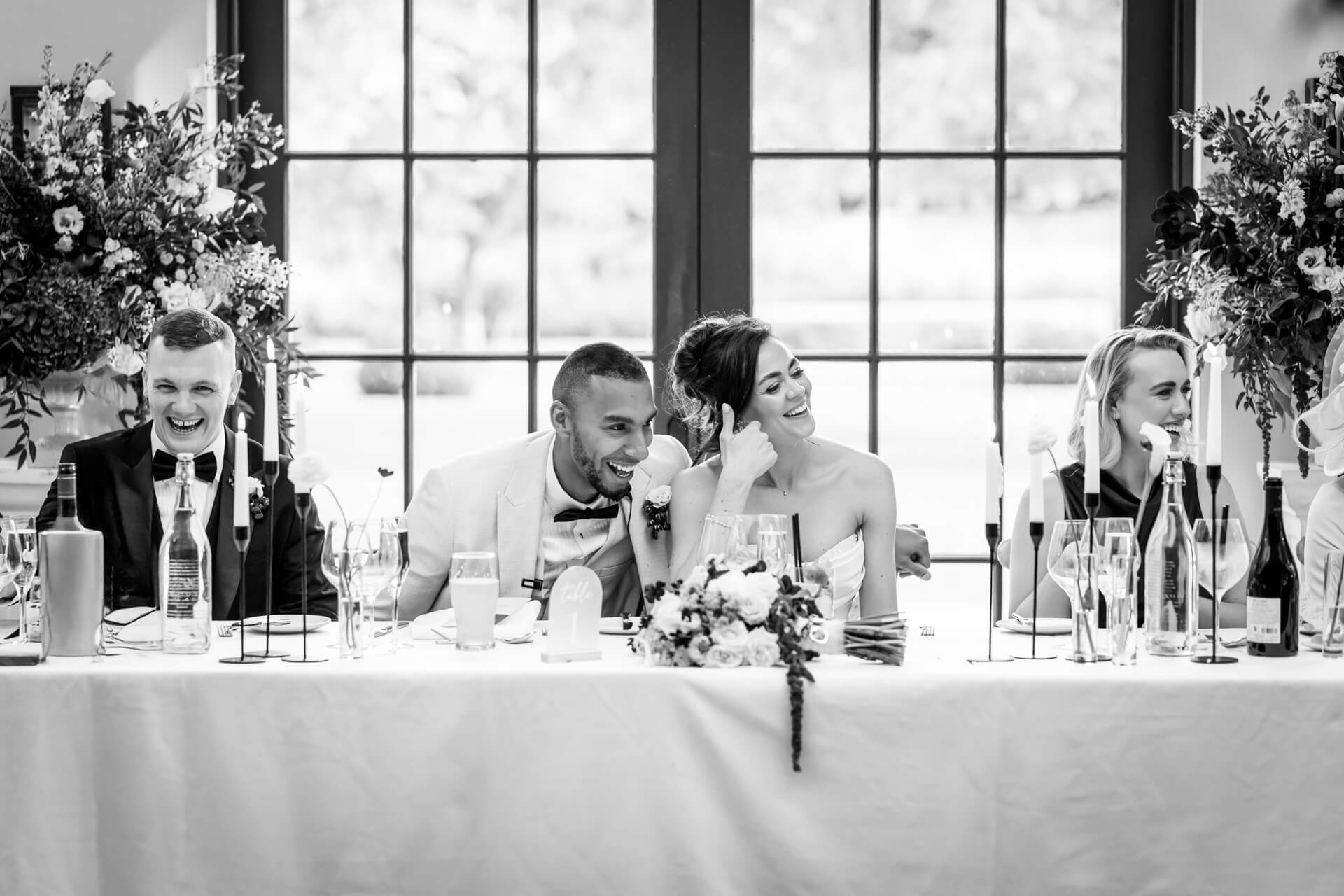 Wedding party laughing at reception table