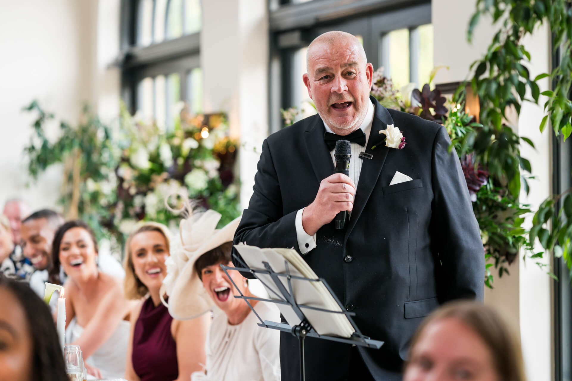 Man delivering a speech at wedding reception.